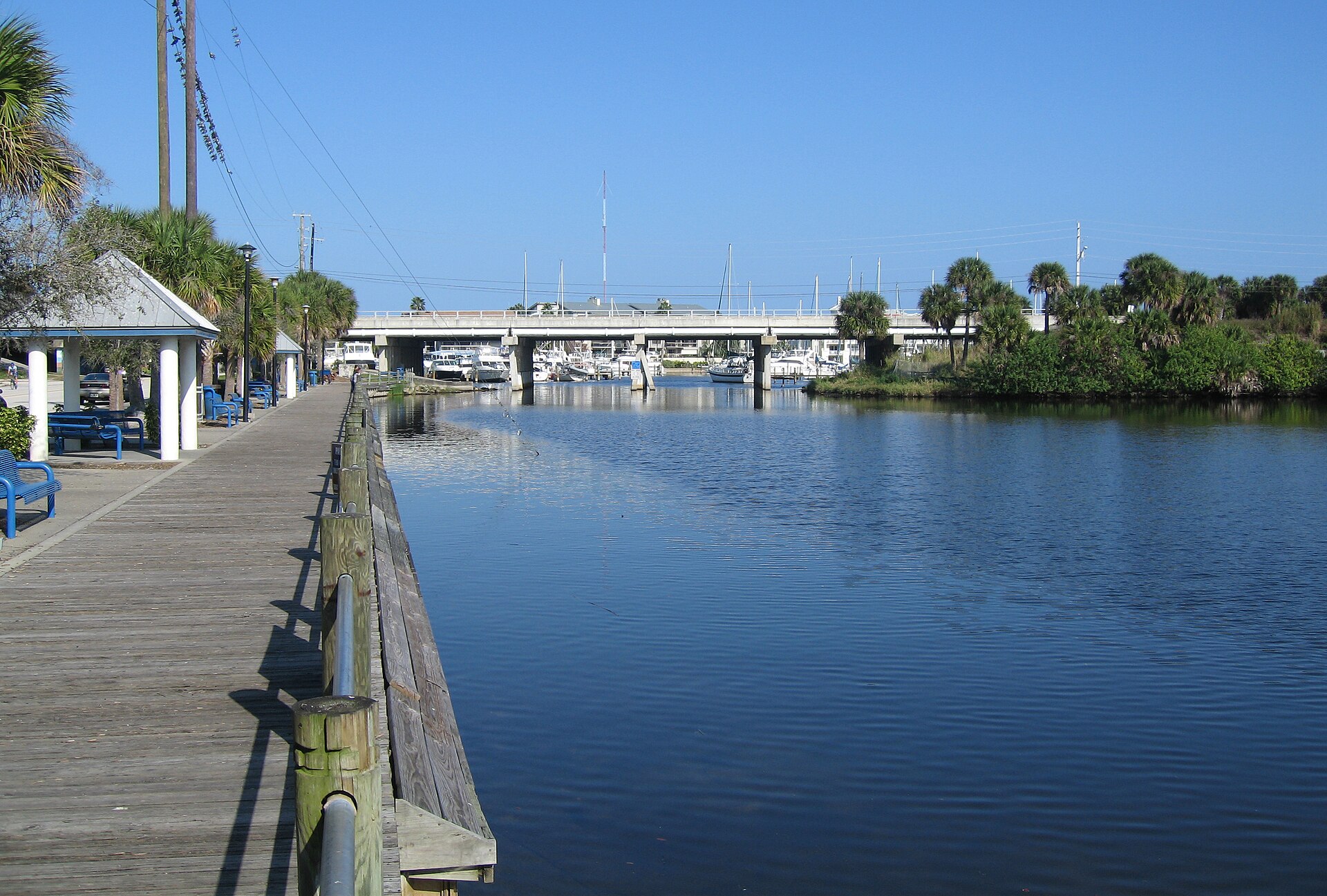 Crane Creek today, a tidal estuary with dark water and overhanging oaks and palms, looking eastward toward the Indian River Lagoon.